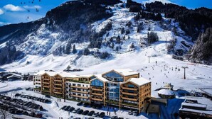 Un hôtel à plusieurs étages avec une piste de ski en arrière-plan.