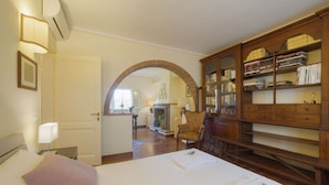 A hotel room with a bed, a wooden bookcase, and a fireplace. - Stunning private villa for 7 people with A/C, private pool, WIFI, patio and panoramic view (Cortona)