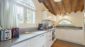 A modern kitchen with white cabinets, a stainless steel toaster, a kettle, and a coffee maker. - Stunning private villa for 7 people with A/C, private pool, WIFI, patio and panoramic view (Cortona)