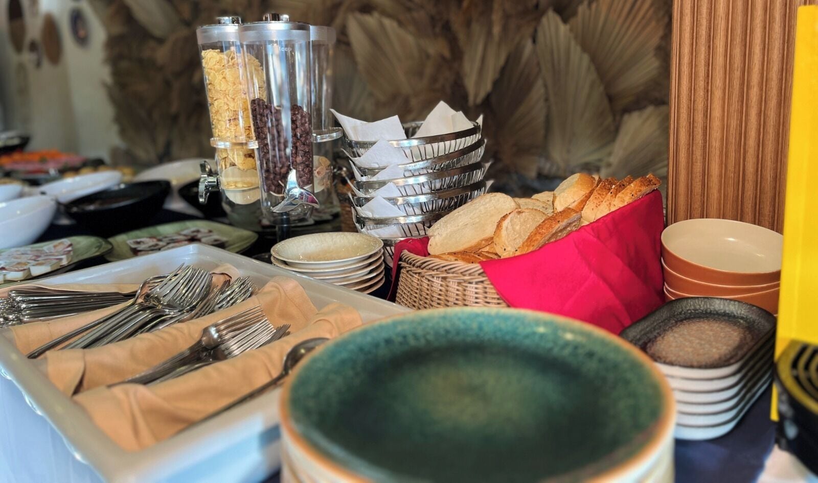 A buffet setup with various food items, utensils, and serving dishes.