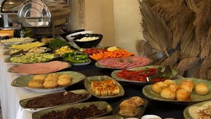 A buffet table with various food items and decorative wall art.