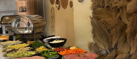 A buffet table with various food items and decorative wall art.