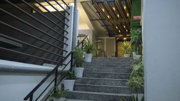 A staircase with metal railings and potted plants. - Hotel Pohor Regency Near Kamakhya Foot Bridge (Guwahati)