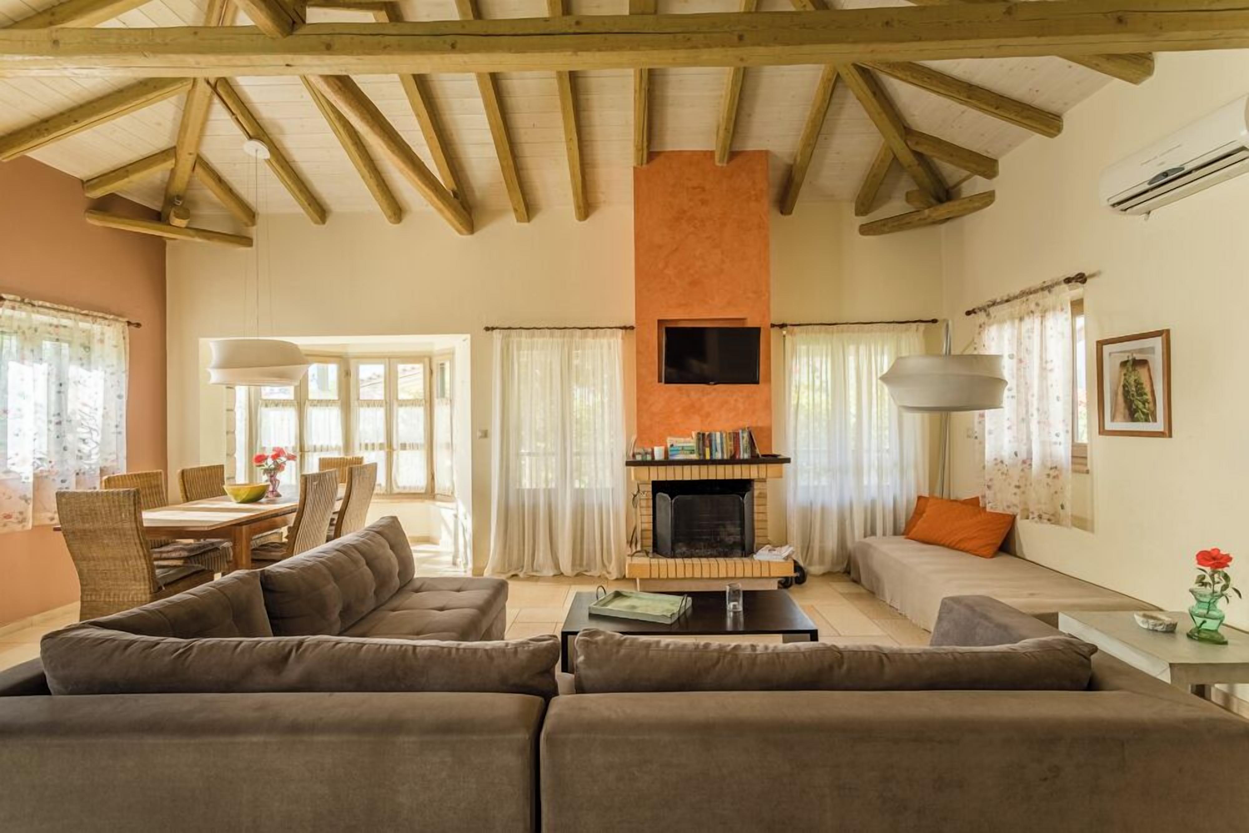 Ein geräumiges Wohnzimmer mit Kamin, Sofas und einem Essbereich mit Tisch und Stühlen.