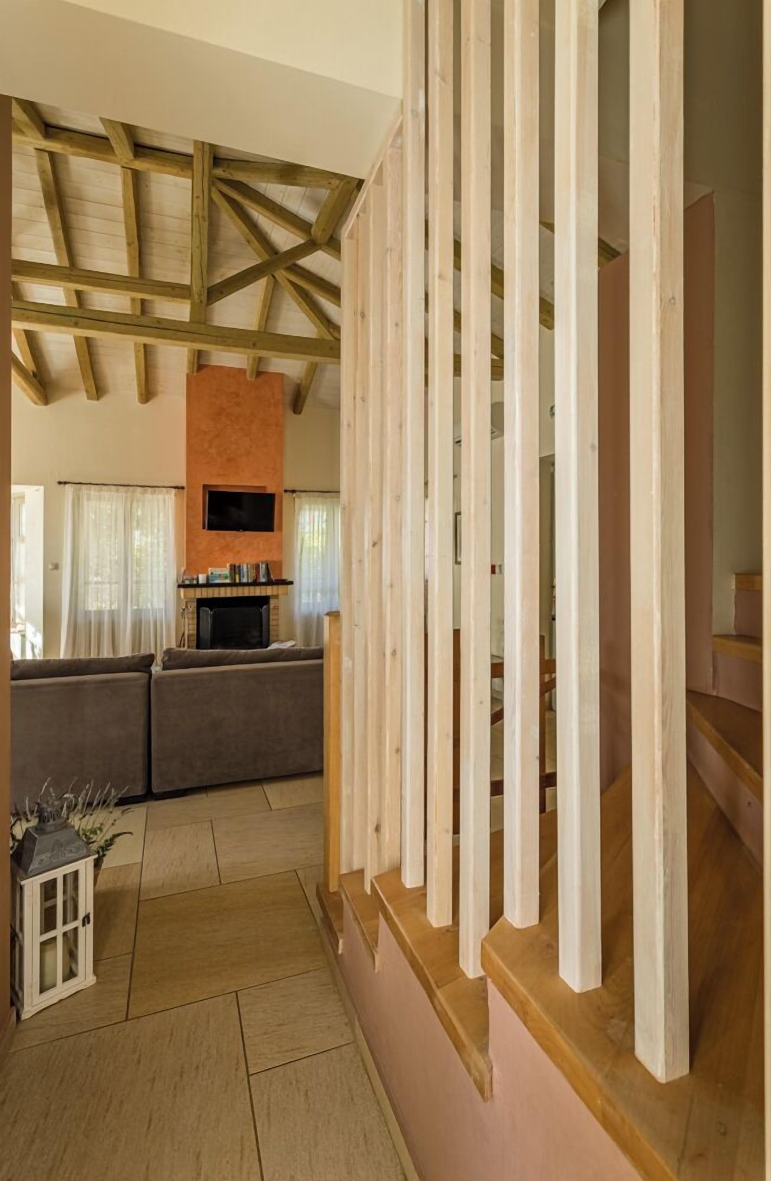 Un amplio espacio de sala de estar con un techo alto, una chimenea y una cocina moderna al fondo.