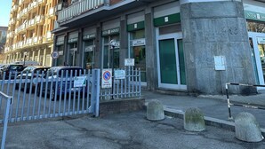 Un immeuble à plusieurs étages doté de balcons, d’une entrée sécurisée et d’enseignes indiquant la présence d’une banque et d’une entreprise.