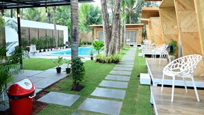 Eine moderne Außenpatio mit Pool, Sitzgelegenheit und Kübelpflanzen.