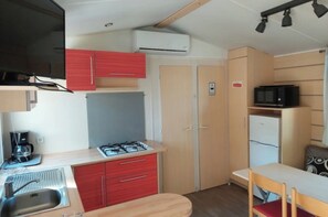 A compact kitchenette with a gas stove, sink, and a microwave. - Super Mercure (5 people)   (La Boissière-de-Montaigu)