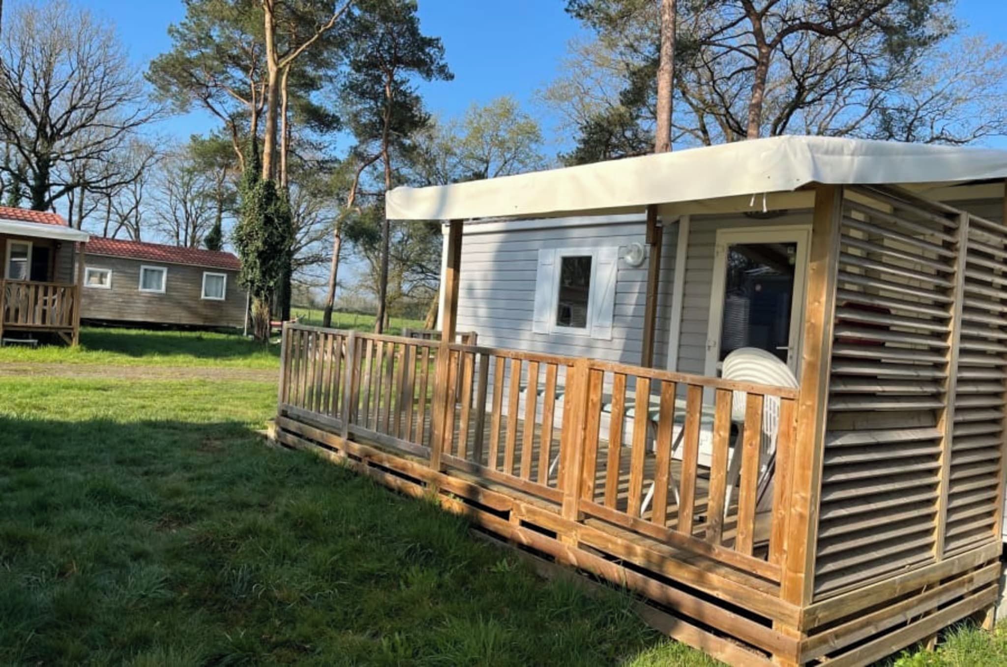 A mobile home with a wooden deck and a covered porch.