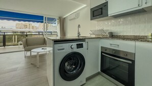 Una cocina moderna equipada con lavadora, horno y microondas integrados.
