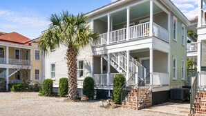 A two-story house with a balcony, a staircase, and a palm tree in the yard. - The Moultrie Suite | Walk to Lamar's Sporting Club (Charleston)