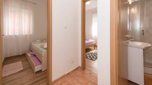 A bedroom with a bed, a bedside table, and a window with curtains.