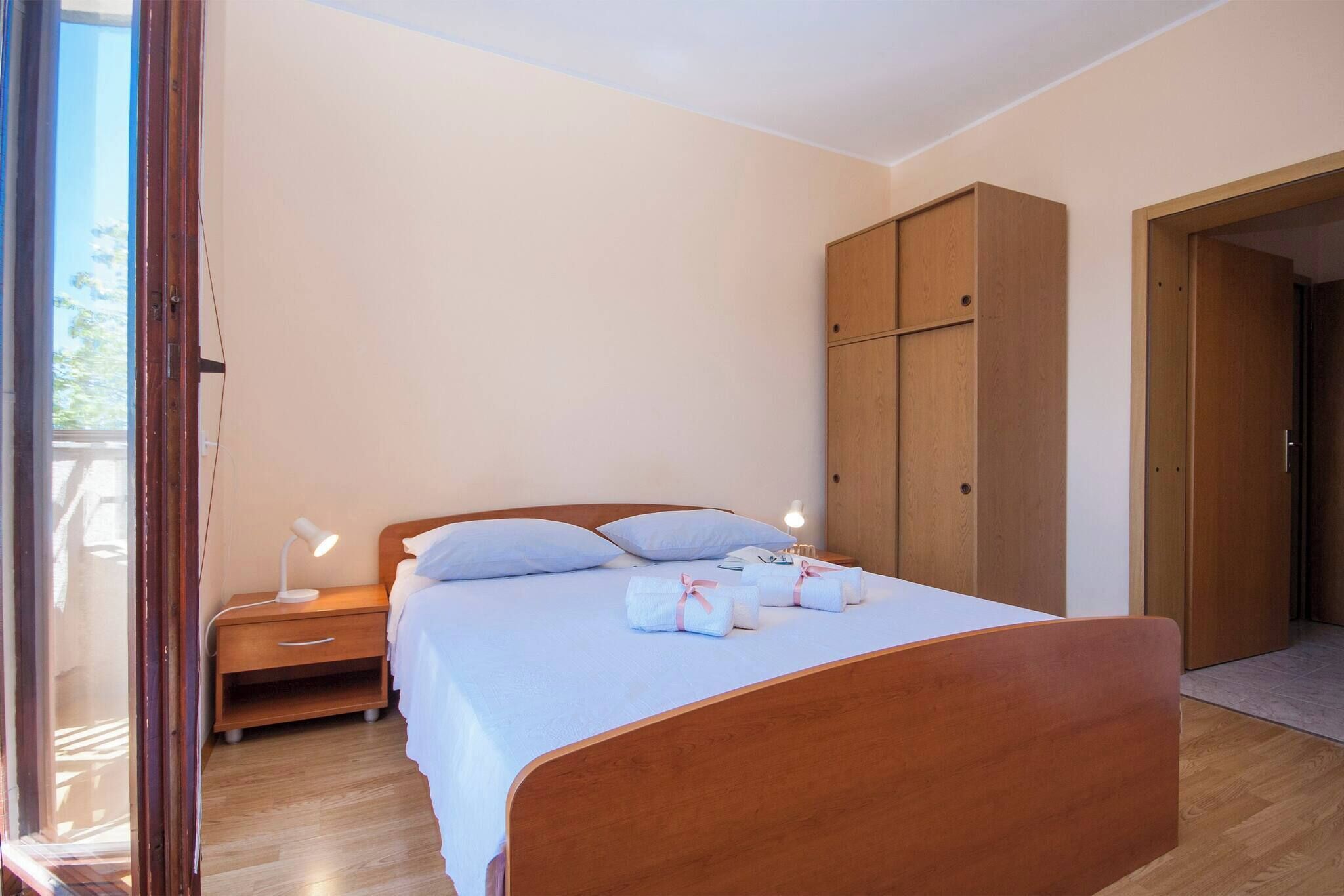 Ein Schlafzimmer mit einem hölzernen Bett, einem Nachttisch mit Lampe und einem Kleiderschrank.