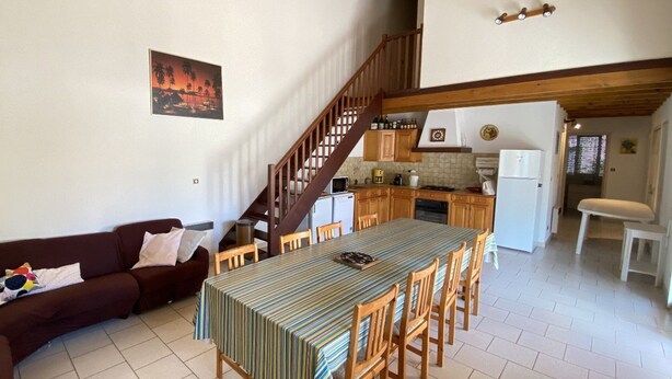 A spacious living area with a dining table, sofa, and kitchen in the background. - Large villa 10 pers near beach, 5 bedrooms, quiet (Valras-Plage)