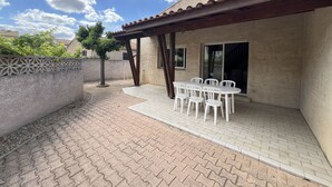 A patio with a tiled floor, a pergola, and a table with chairs. - Large villa 10 pers near beach, 5 bedrooms, quiet (Valras-Plage)