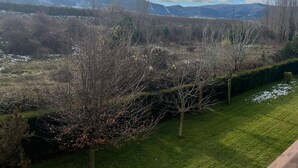 Un paysage comprenant une zone herbeuse, des arbres et des montagnes en arrière-plan.