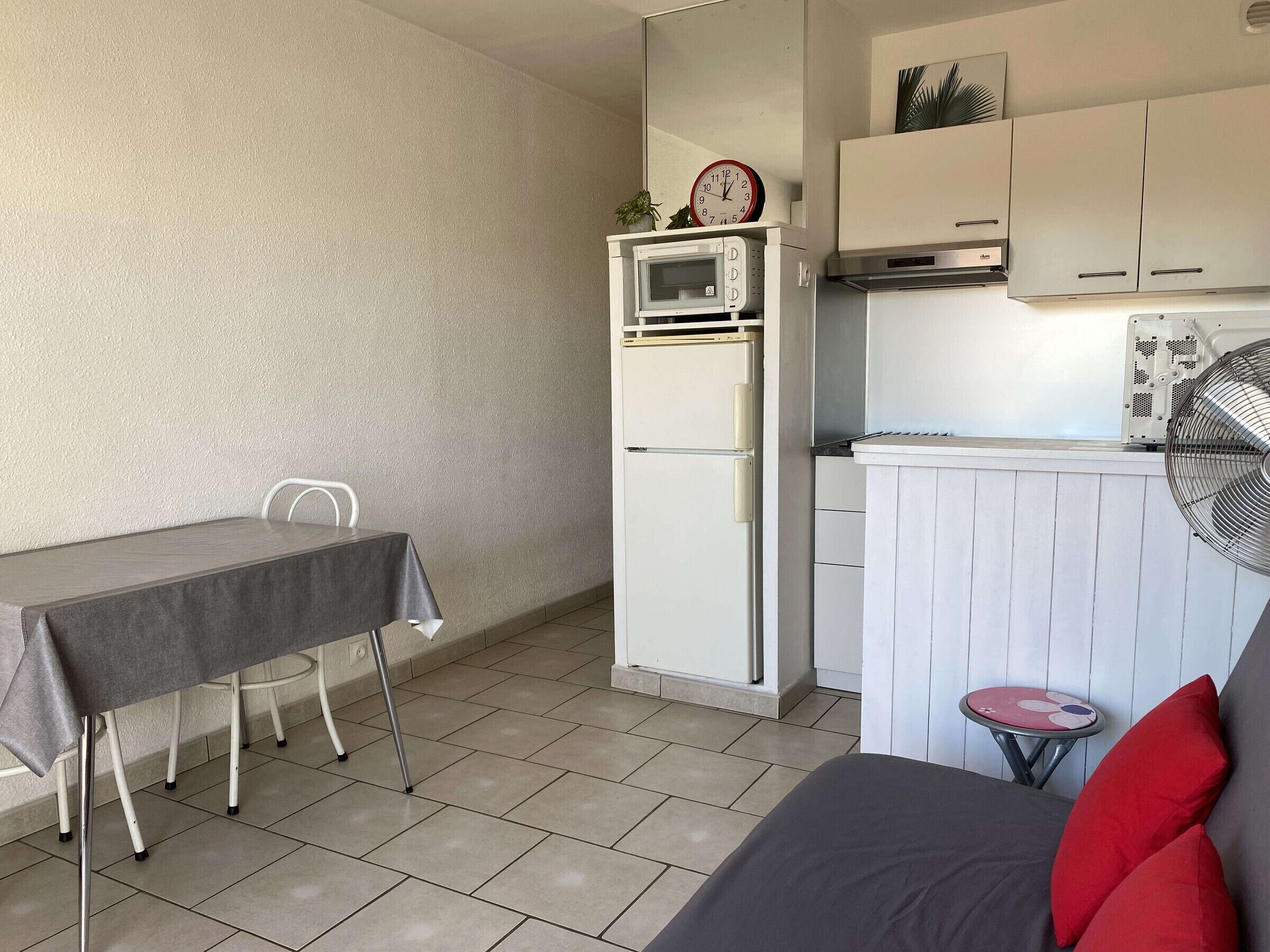 A compact living space with a kitchenette, a dining area, and a seating area.