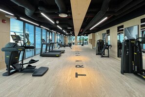 Ein Fitnessstudio mit Laufbändern, Crosstrainern und Krafttrainingsgeräten.