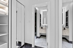 Ein modernes Badezimmer mit einem großen Spiegel, einem Waschbecken und einer Toilette.