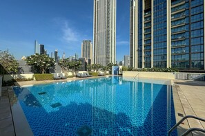 A rooftop pool with lounge chairs, surrounded by high-rise buildings. - Luxury 1 Bedroom in the Heart of Famous Downtown (Dubai)