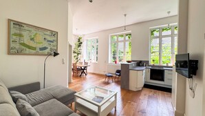 A modern apartment with a dining area, kitchen, and living room.