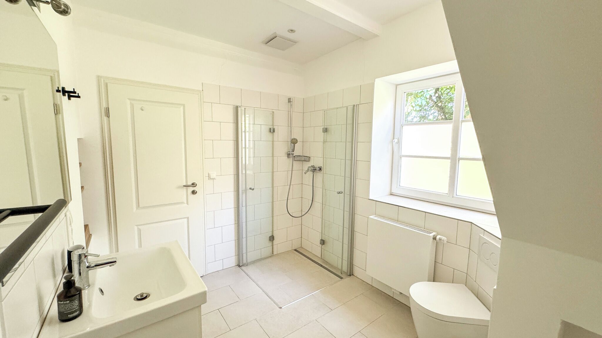 A bathroom with a shower, toilet, and sink.