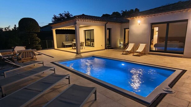 A swimming pool with lounge chairs, a covered patio, and a bedroom with sliding glass doors. - Modern villa with private pool, air-conditioned, near Vallon Pont d'Arc center (Vallon-Pont-d'Arc)