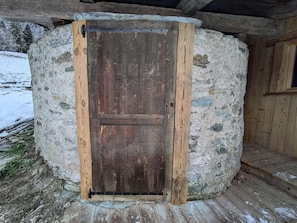 A rustic stone building with a wooden door, a wooden staircase, and a window. - Chalet 4 bedrooms, modern comfort, Arêches-Beaufort (Arêches-Beaufort)