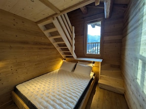 A wooden cabin room with a bed, a window, and a staircase. - Chalet 4 bedrooms, modern comfort, Arêches-Beaufort (Arêches-Beaufort)