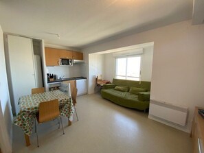 A compact living space with a kitchenette, a dining area, and a sofa.