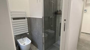 Een douche, een haardroger, een bidet, handdoeken