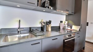 Une cuisine moderne équipée d’appareils électroménagers en acier inoxydable, d’un four encastré et d’un lave-vaisselle.