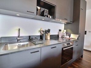 A modern kitchen with stainless steel appliances, a built-in oven, and a dishwasher.