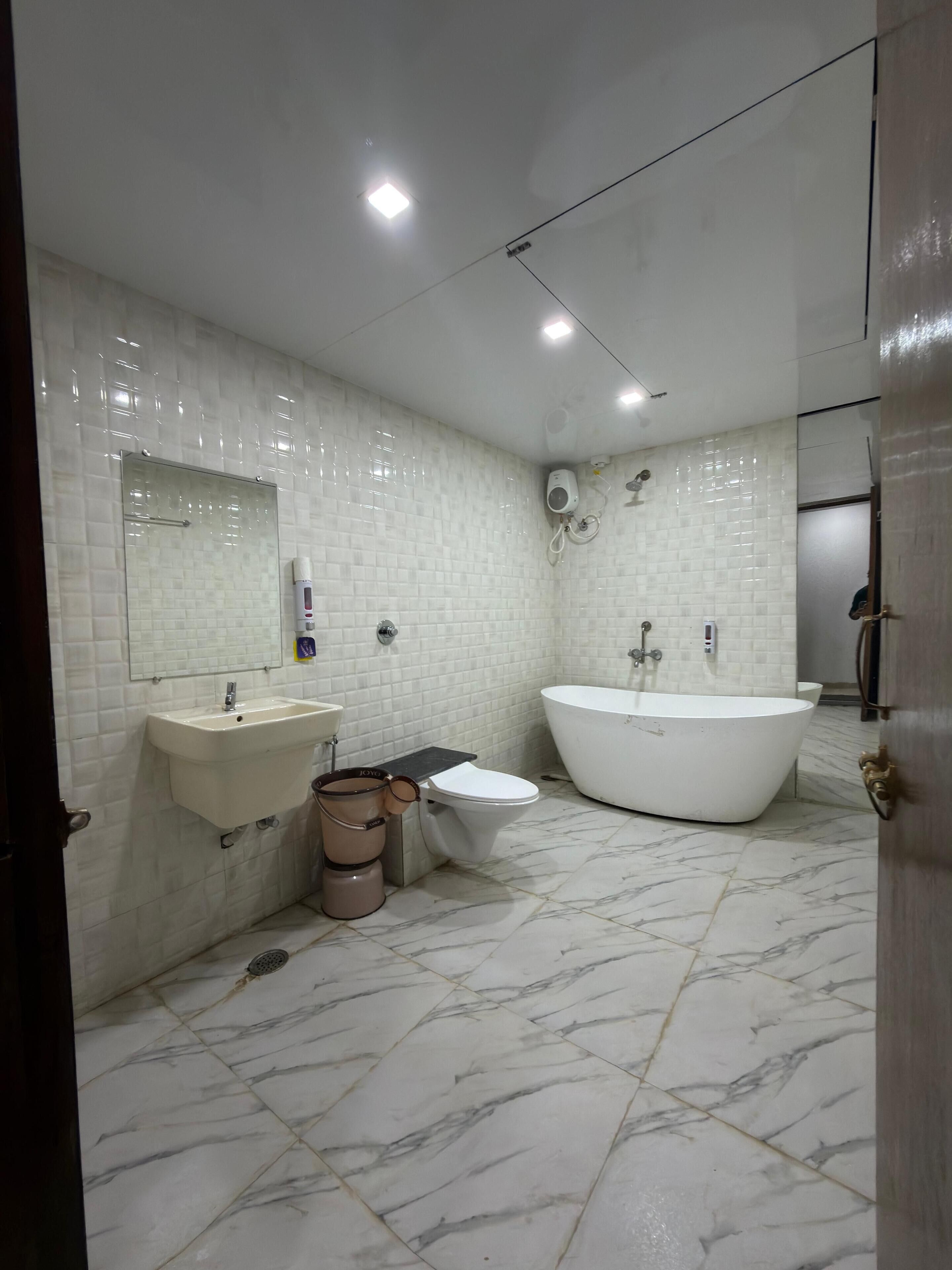 Un bagno moderno con una vasca da bagno indipendente, un lavandino e un water.