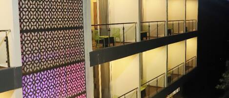 A multi-story hotel with balconies, indoor and outdoor seating areas, and a decorative facade.