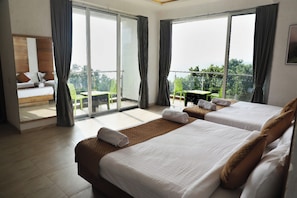 A hotel room with two beds, a balcony with a table and chairs, and a view of the outdoors. - Aakaar Valley (Moleshwar)