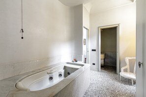 Une salle de bain moderne avec une grande baignoire sur pieds, des toilettes et un lavabo.