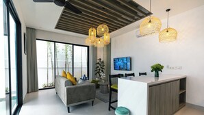 Un salon moderne comprenant un canapé, un coin repas et un îlot de cuisine.
