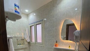 Une salle de bain moderne avec une douche à parois de verre, un lavabo blanc, des toilettes et un meuble-lavabo avec un miroir.