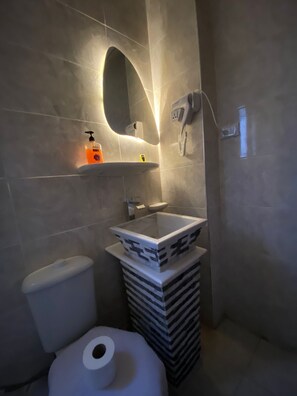 A modern bathroom with a toilet, a sink, and a mirror. - Experieance Pyramids VIEW (Giza)