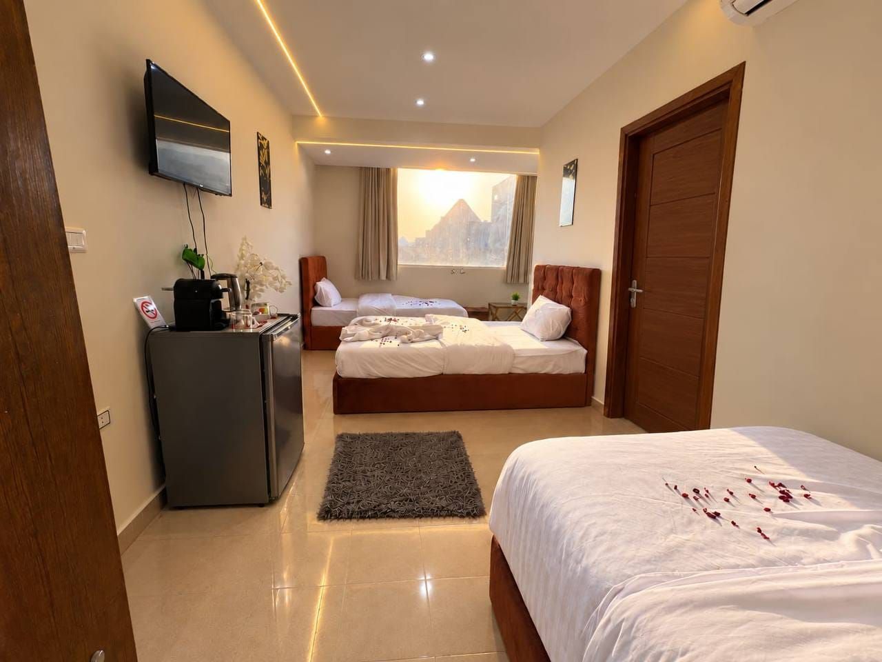 Una habitación de hotel con cama, escritorio, televisor y ventana con vista a la montaña.