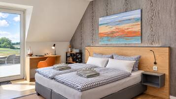 Ein modernes Schlafzimmer mit einem großen Bett, einem Schreibtisch und Blick ins Freie.