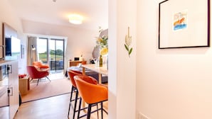 Een moderne keuken met een eethoek, een groot raam en een kunstwerk in een lijst aan de muur.