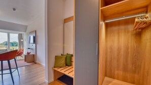 Una habitación moderna con un banco de madera, un televisor y vistas al exterior.
