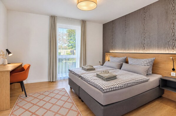 Une chambre moderne avec un grand lit, un bureau et une chaise.
