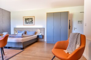 Cozy retreat with a neatly made bed, bedside table, and spacious wardrobe.