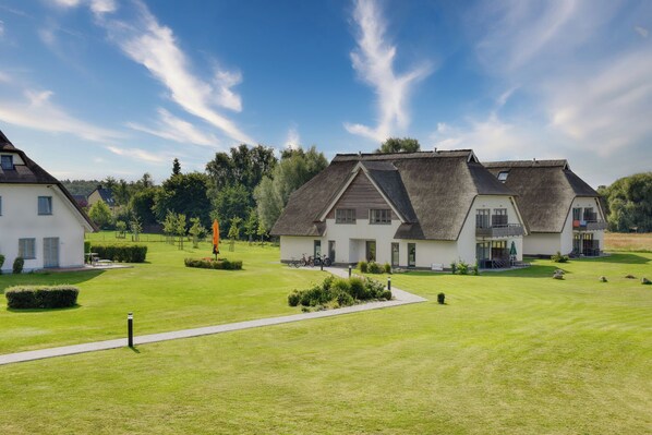 A residential area with two houses featuring gabled roofs and a well-maintained lawn.