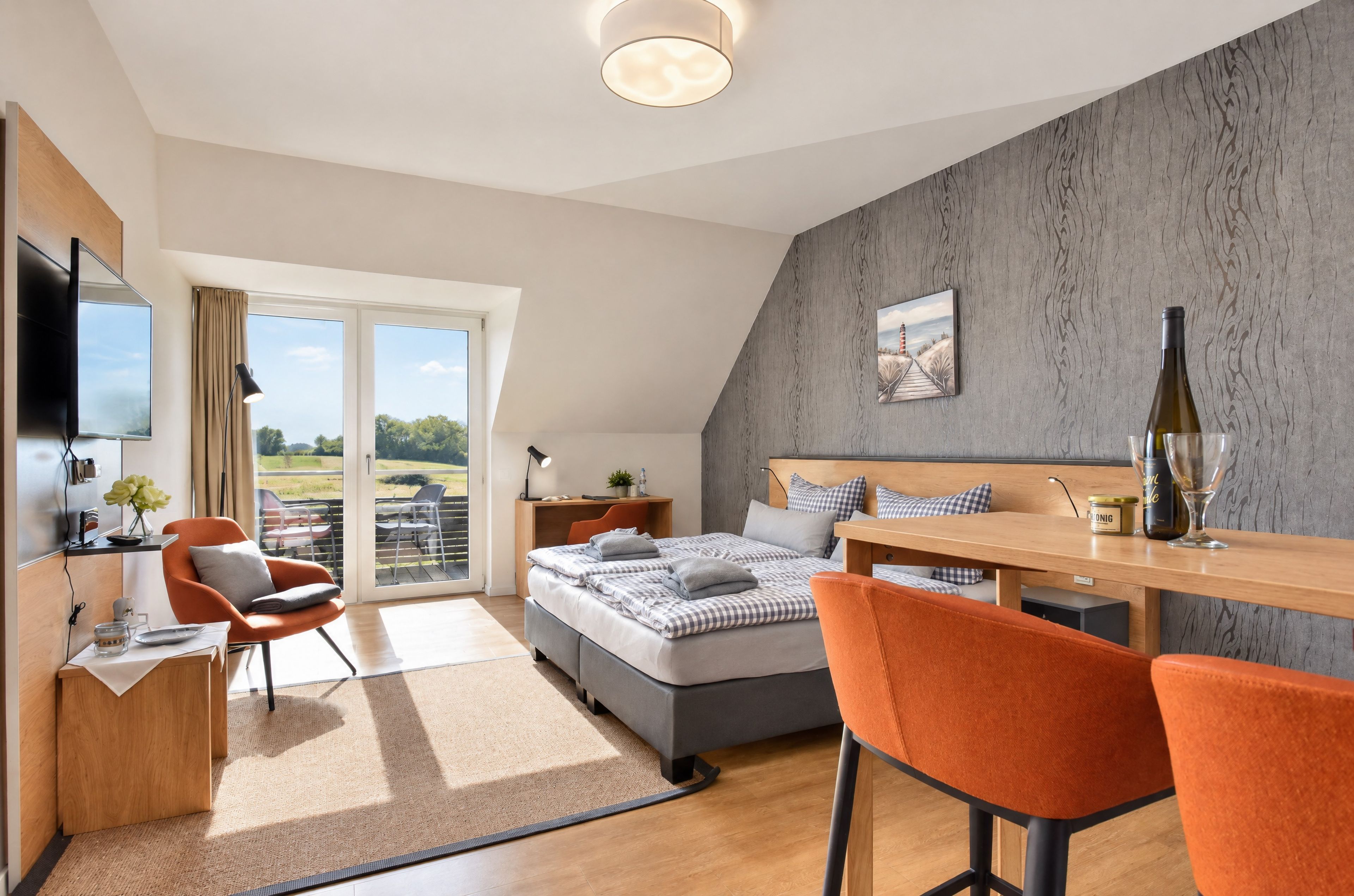 A modern bedroom with a bed, a desk, a chair, a TV, and a balcony with a view.