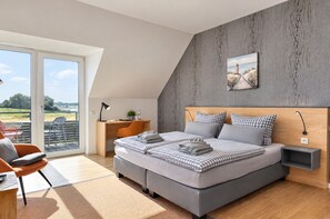 Een moderne slaapkamer met een groot bed, een bureau en uitzicht op de omgeving.