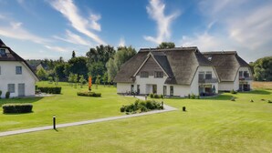 A residential area with two houses featuring gabled roofs and a well-maintained lawn.